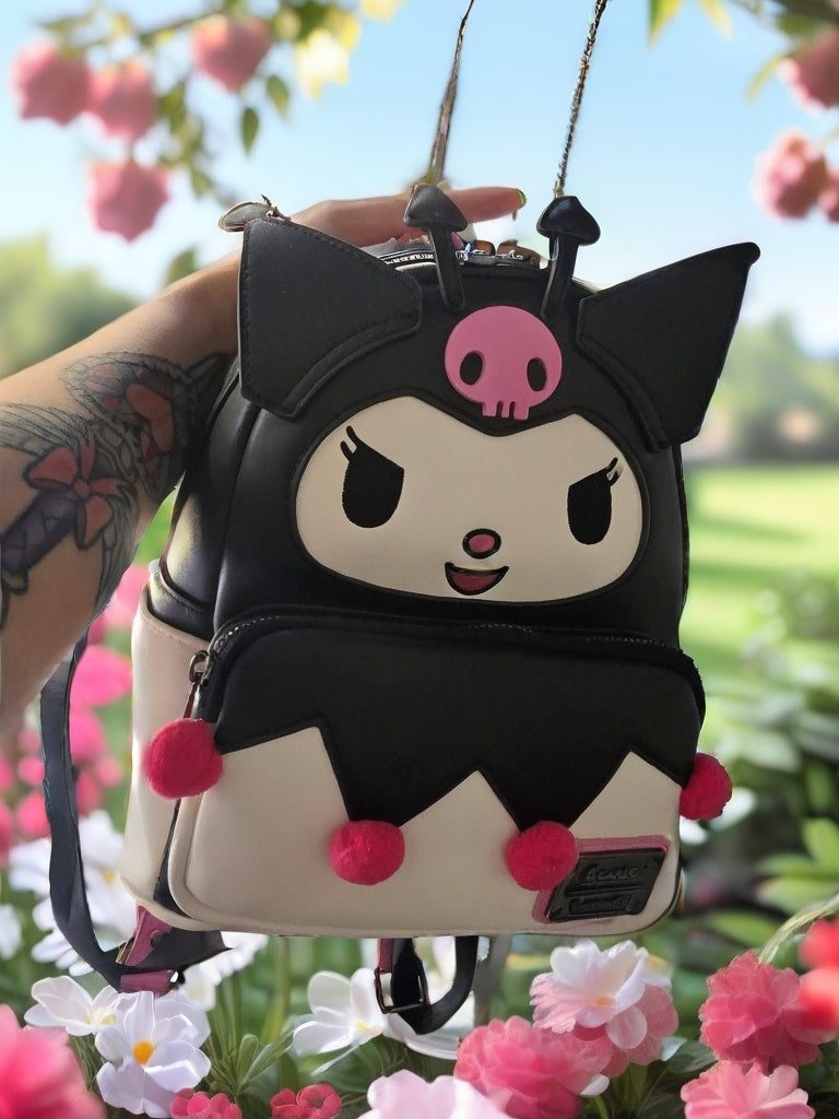Sanrio Kuromi mini backpack in black and cream vegan leather with pink pom-poms and jester face design